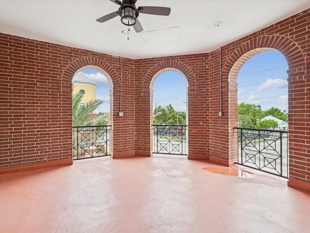 2010 E Palm Ave Unit 14303, Tampa, FL 33605 - empty room featuring brick wall, plenty of natural light, a ceiling fan, and concrete floors