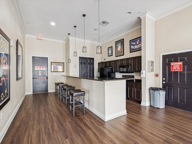 2010 E Palm Ave Unit 14303, Tampa, FL 33605 - kitchen with black appliances, a kitchen bar, dark wood-style floors, dark brown cabinets, and ornamental molding