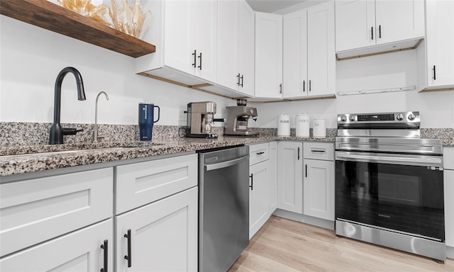 9429 Northcliffe Blvd, Spring Hill, FL 34606 - kitchen with appliances with stainless steel finishes, open shelves, stone countertops, light wood-type flooring, and white cabinets