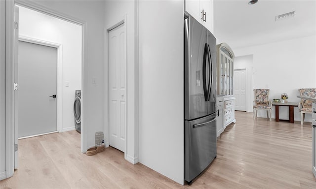 9429 Northcliffe Blvd, Spring Hill, FL 34606 - kitchen with freestanding refrigerator, white cabinets, light wood finished floors, and washer / dryer