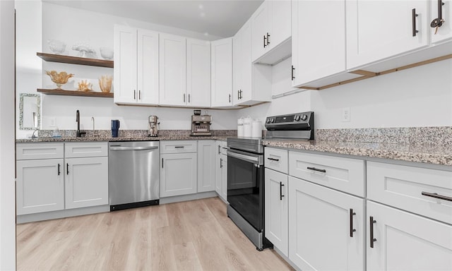 9429 Northcliffe Blvd, Spring Hill, FL 34606 - kitchen featuring stainless steel appliances, light wood-type flooring, light stone countertops, and white cabinetry
