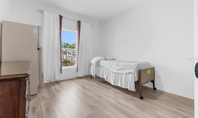 9429 Northcliffe Blvd, Spring Hill, FL 34606 - bedroom featuring light wood-style floors and freestanding refrigerator