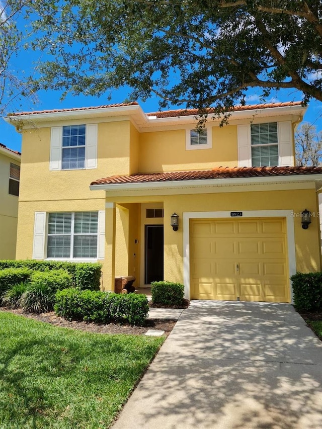 8923 Cuban Palm Rd, Kissimmee, FL 34747 - view of front of house with a tile roof, a garage, stucco siding, and concrete driveway