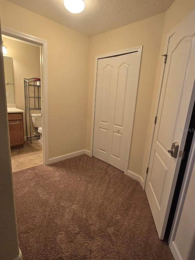 8923 Cuban Palm Rd, Kissimmee, FL 34747 - unfurnished bedroom with carpet flooring, a textured ceiling, a closet, and connected bathroom