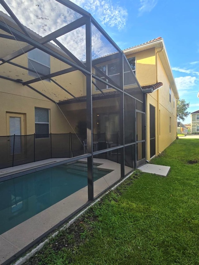 8923 Cuban Palm Rd, Kissimmee, FL 34747 - back of property featuring glass enclosure, stucco siding, a yard, an outdoor pool, and a patio