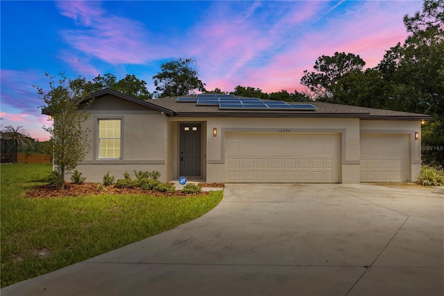 12277 Spring Hill Dr, Spring Hill, FL 34609 - ranch-style home with an attached garage, driveway, roof mounted solar panels, stucco siding, and a front lawn