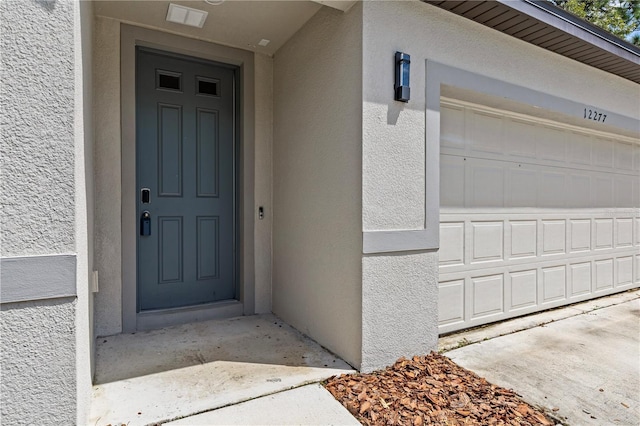 12277 Spring Hill Dr, Spring Hill, FL 34609 - property entrance with stucco siding and a garage