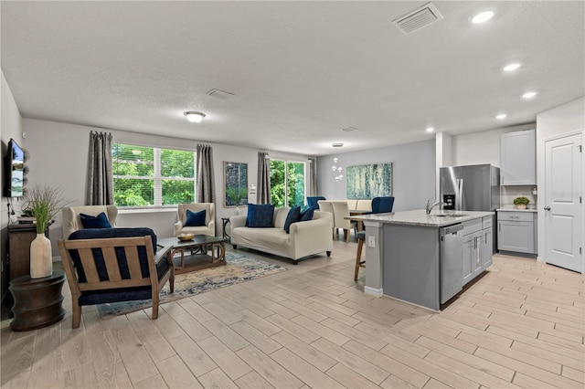 12277 Spring Hill Dr, Spring Hill, FL 34609 - kitchen featuring stainless steel appliances, open floor plan, recessed lighting, a kitchen island with sink, and a kitchen bar