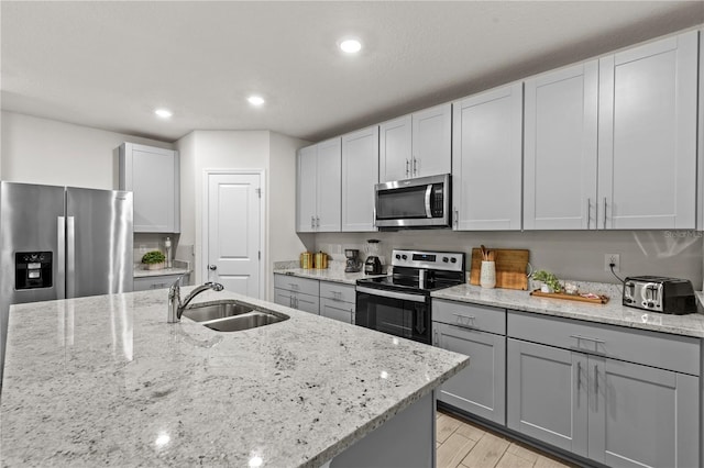 12277 Spring Hill Dr, Spring Hill, FL 34609 - kitchen featuring appliances with stainless steel finishes, light stone countertops, light wood-style floors, gray cabinets, and recessed lighting