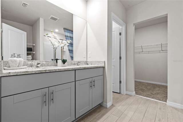 12277 Spring Hill Dr, Spring Hill, FL 34609 - bathroom featuring double vanity, wood finished floors, and a spacious closet