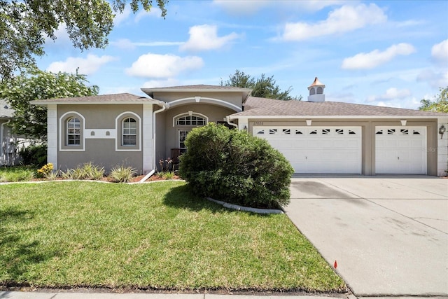 27826 Sora Blvd, Wesley Chapel, FL 33544 - view of front of home with a garage, concrete driveway, a front yard, stucco siding, and a shingled roof