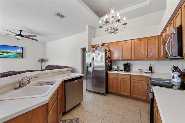 27826 Sora Blvd, Wesley Chapel, FL 33544 - kitchen featuring appliances with stainless steel finishes, brown cabinets, a chandelier, light tile patterned floors, and a ceiling fan