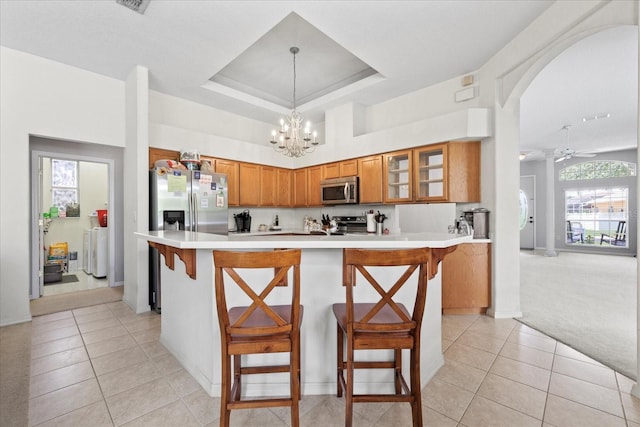 27826 Sora Blvd, Wesley Chapel, FL 33544 - kitchen with stainless steel appliances, light tile patterned floors, brown cabinetry, and light countertops