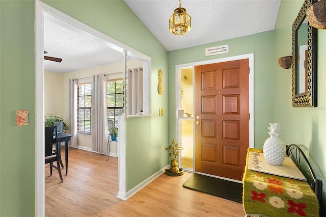 7022 Kingsway Dr, Port Richey, FL 34668 - foyer entrance with wood finished floors, a chandelier, and a textured ceiling