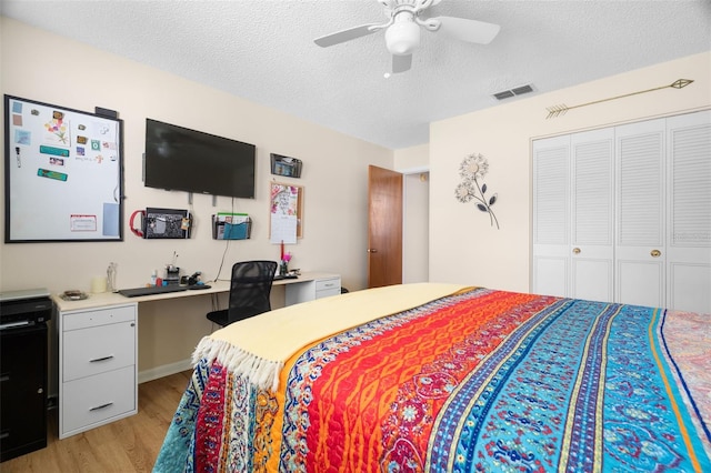 7022 Kingsway Dr, Port Richey, FL 34668 - bedroom with light wood finished floors, a textured ceiling, a closet, and ceiling fan