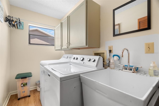 7022 Kingsway Dr, Port Richey, FL 34668 - laundry room featuring cabinet space, washing machine and dryer, light wood-style floors, and a textured ceiling