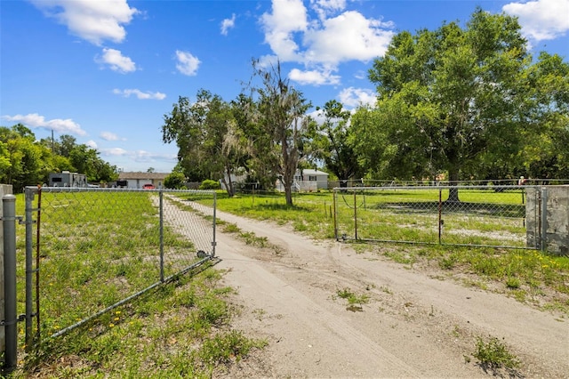 2221 W Lake Dr, Wimauma, FL 33598 - view of dirt / gravel driveway with a gated entry, a gate, and a view of rural / pastoral area