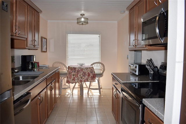 3200 Cove Cay Dr Unit 5F, Clearwater, FL 33760 - kitchen featuring appliances with stainless steel finishes, brown cabinetry, and light tile patterned floors