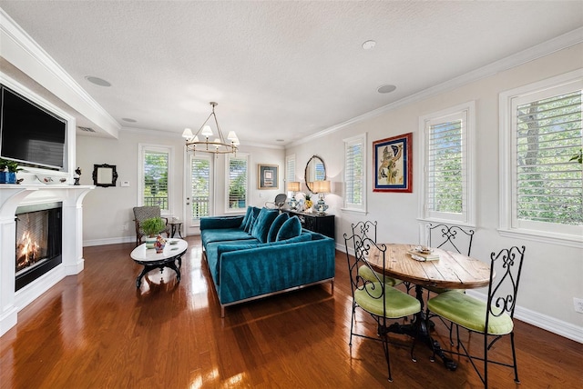 1731 W Watrous Ave Unit 202, Tampa, FL 33606 - living room featuring a chandelier, wood finished floors, a glass covered fireplace, a textured ceiling, and ornamental molding