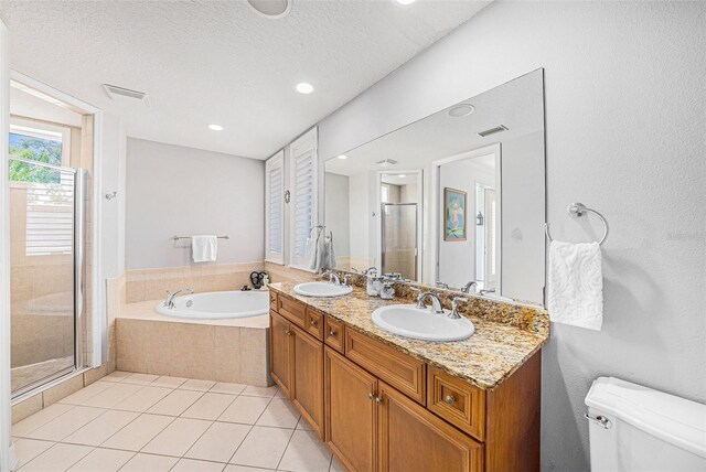 1731 W Watrous Ave Unit 202, Tampa, FL 33606 - bathroom with a bath, a stall shower, double vanity, tile patterned floors, and a textured ceiling