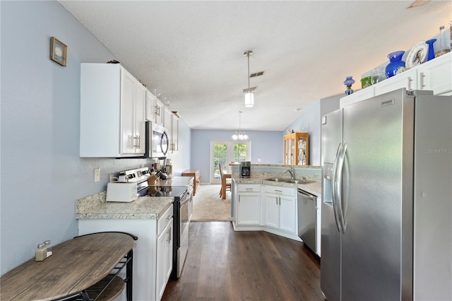7804 Country Chase Ave, Lakeland, FL 33810 - kitchen with appliances with stainless steel finishes, a peninsula, white cabinets, dark wood-type flooring, and a textured ceiling