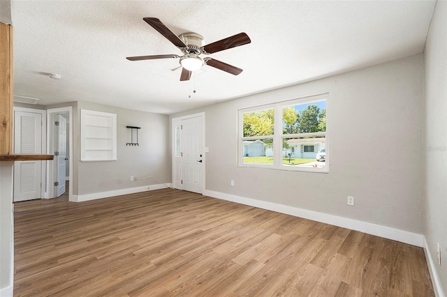 3509 Brookston Dr, Holiday, FL 34691 - unfurnished living room featuring light wood-type flooring, ceiling fan, and a textured ceiling