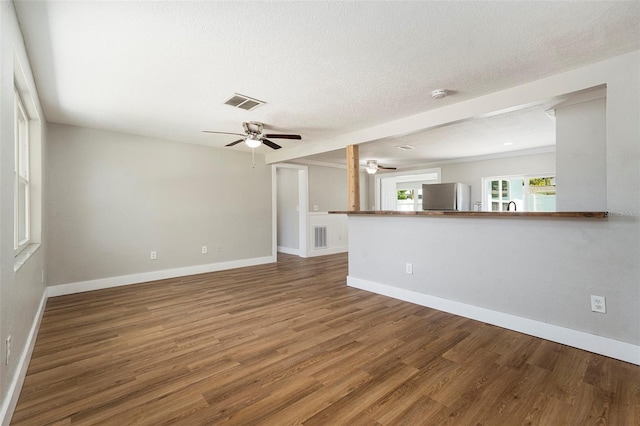 3509 Brookston Dr, Holiday, FL 34691 - unfurnished living room featuring a ceiling fan, wood finished floors, and a textured ceiling