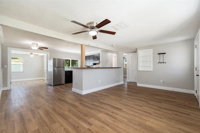3509 Brookston Dr, Holiday, FL 34691 - unfurnished living room featuring ceiling fan, wood finished floors, and a textured ceiling