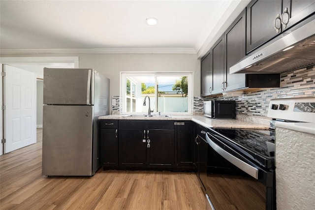 3509 Brookston Dr, Holiday, FL 34691 - kitchen with electric range, freestanding refrigerator, under cabinet range hood, ornamental molding, and black microwave