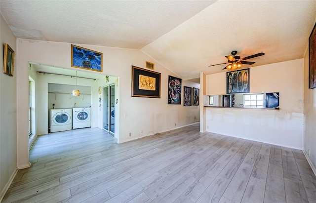 5265 E Bay Dr Unit 521, Clearwater, FL 33764 - unfurnished room featuring washing machine and dryer, wood finished floors, ceiling fan, vaulted ceiling, and a textured ceiling