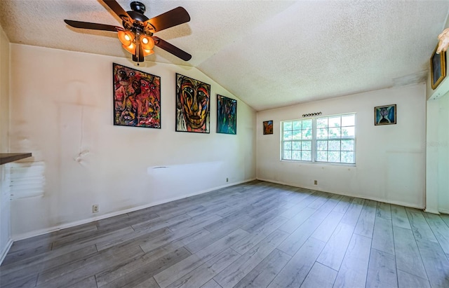 5265 E Bay Dr Unit 521, Clearwater, FL 33764 - unfurnished room with a textured ceiling, a ceiling fan, wood finished floors, and vaulted ceiling
