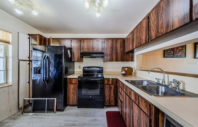 5265 E Bay Dr Unit 521, Clearwater, FL 33764 - kitchen featuring black appliances, under cabinet range hood, light countertops, and light wood-style flooring