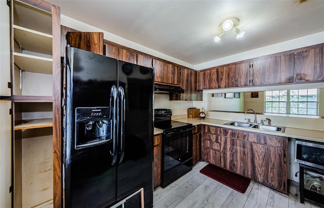 5265 E Bay Dr Unit 521, Clearwater, FL 33764 - kitchen featuring black appliances, light countertops, light wood-type flooring, and under cabinet range hood
