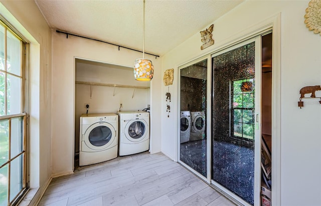 5265 E Bay Dr Unit 521, Clearwater, FL 33764 - laundry room featuring separate washer and dryer, healthy amount of natural light, a textured ceiling, and light wood-style floors