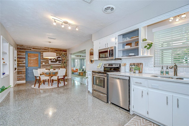 2201 Horan Way S, Gulfport, FL 33707 - kitchen featuring appliances with stainless steel finishes, open shelves, light countertops, white cabinetry, and a textured ceiling
