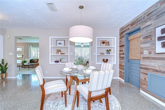 2201 Horan Way S, Gulfport, FL 33707 - dining area with wood walls, built in features, a textured ceiling, speckled floor, and ceiling fan