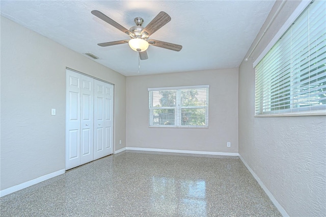 2201 Horan Way S, Gulfport, FL 33707 - unfurnished bedroom featuring a textured wall, a closet, ceiling fan, and speckle patterned floor