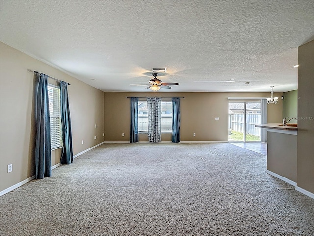 12121 Tree Haven Ave, Gibsonton, FL 33534 - unfurnished room featuring a chandelier, light carpet, a textured ceiling, and ceiling fan