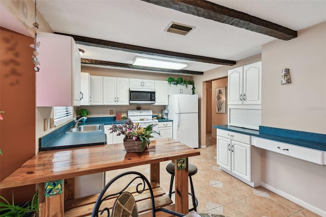 855 Pinewood Ter W, Palm Harbor, FL 34683 - kitchen featuring white appliances, beam ceiling, white cabinetry, light tile patterned floors, and a textured ceiling