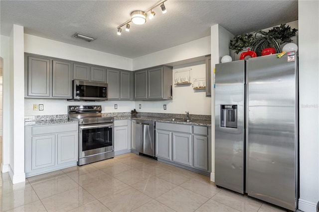 7819 Carriage Pointe Dr, Gibsonton, FL 33534 - kitchen featuring appliances with stainless steel finishes, gray cabinets, a textured ceiling, and stone counters