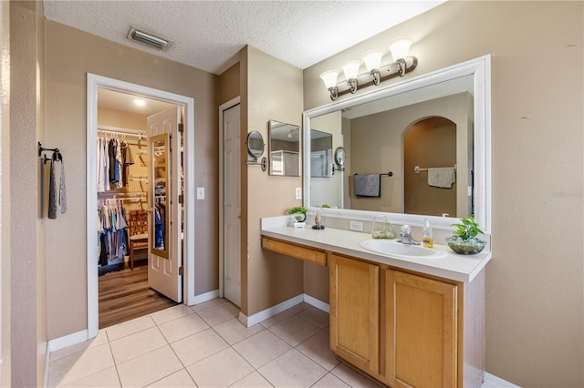 7819 Carriage Pointe Dr, Gibsonton, FL 33534 - bathroom featuring tile patterned floors, vanity, a spacious closet, and a textured ceiling