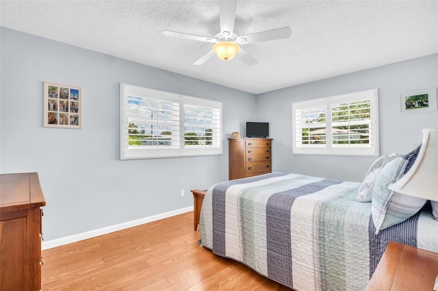 2814 Highlands Blvd Unit B, Palm Harbor, FL 34684 - bedroom featuring light wood finished floors, a textured ceiling, and ceiling fan