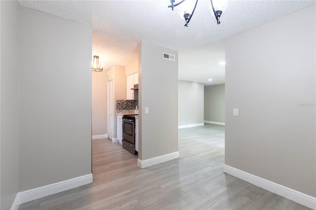 3805 Cortez Cir Unit B, Tampa, FL 33614 - hall featuring a chandelier, light wood-style flooring, and a textured ceiling