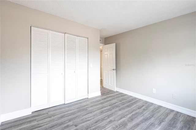 3805 Cortez Cir Unit B, Tampa, FL 33614 - unfurnished bedroom with wood finished floors, a closet, and a textured ceiling