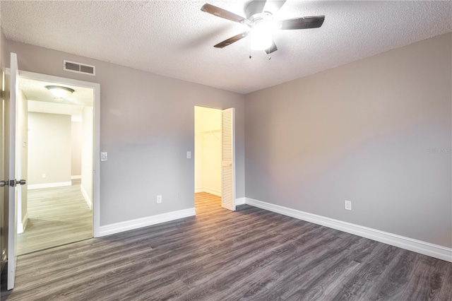 3805 Cortez Cir Unit B, Tampa, FL 33614 - unfurnished bedroom with dark wood-style flooring, a closet, a textured ceiling, and a ceiling fan