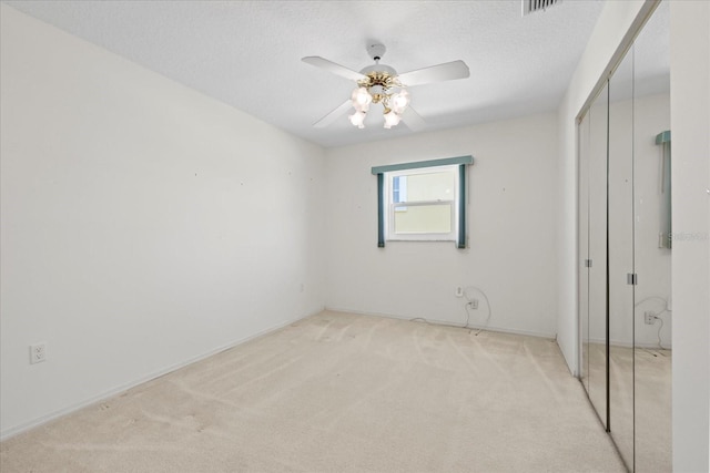 17025 Dolphin Dr, North Redington Beach, FL 33708 - unfurnished bedroom featuring a closet, light carpet, a ceiling fan, and a textured ceiling