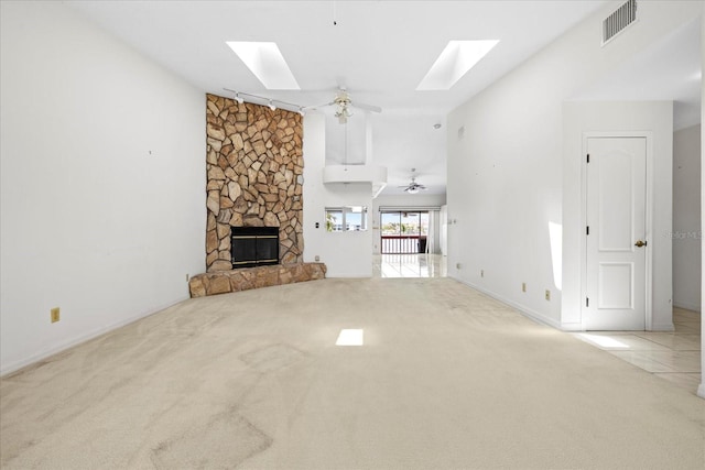 17025 Dolphin Dr, North Redington Beach, FL 33708 - unfurnished living room featuring a skylight, carpet floors, a stone fireplace, and ceiling fan