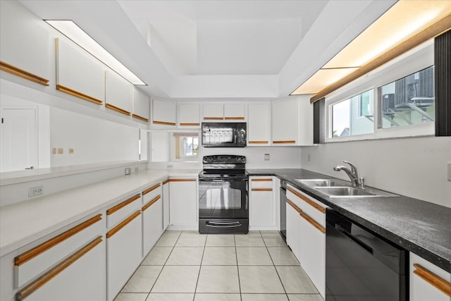 17025 Dolphin Dr, North Redington Beach, FL 33708 - kitchen with black appliances, light tile patterned floors, white cabinets, and a raised ceiling