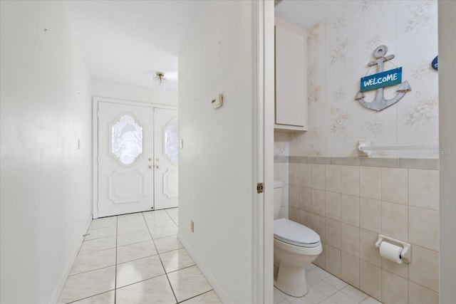 17025 Dolphin Dr, North Redington Beach, FL 33708 - bathroom with tile patterned flooring, wallpapered walls, and wainscoting