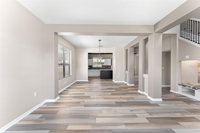 1291 Blackrush Dr, Tarpon Springs, FL 34689 - unfurnished dining area with a chandelier, light wood-style floors, and stairway
